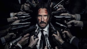 keanu reeves rodeado de armas que le apuntan a la cabeza